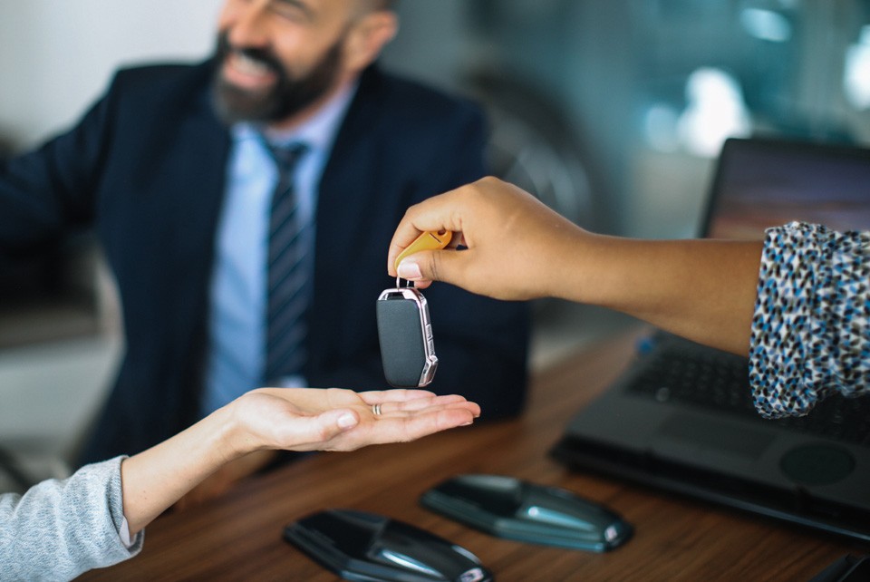 hand outstretched with car key handoff