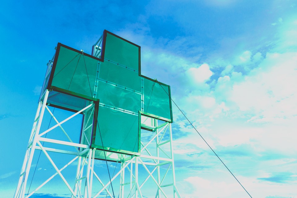 green hospital symbol outdoor sign