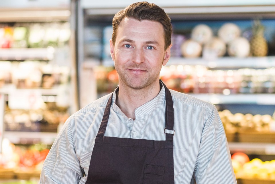 grocer standing in grocery store