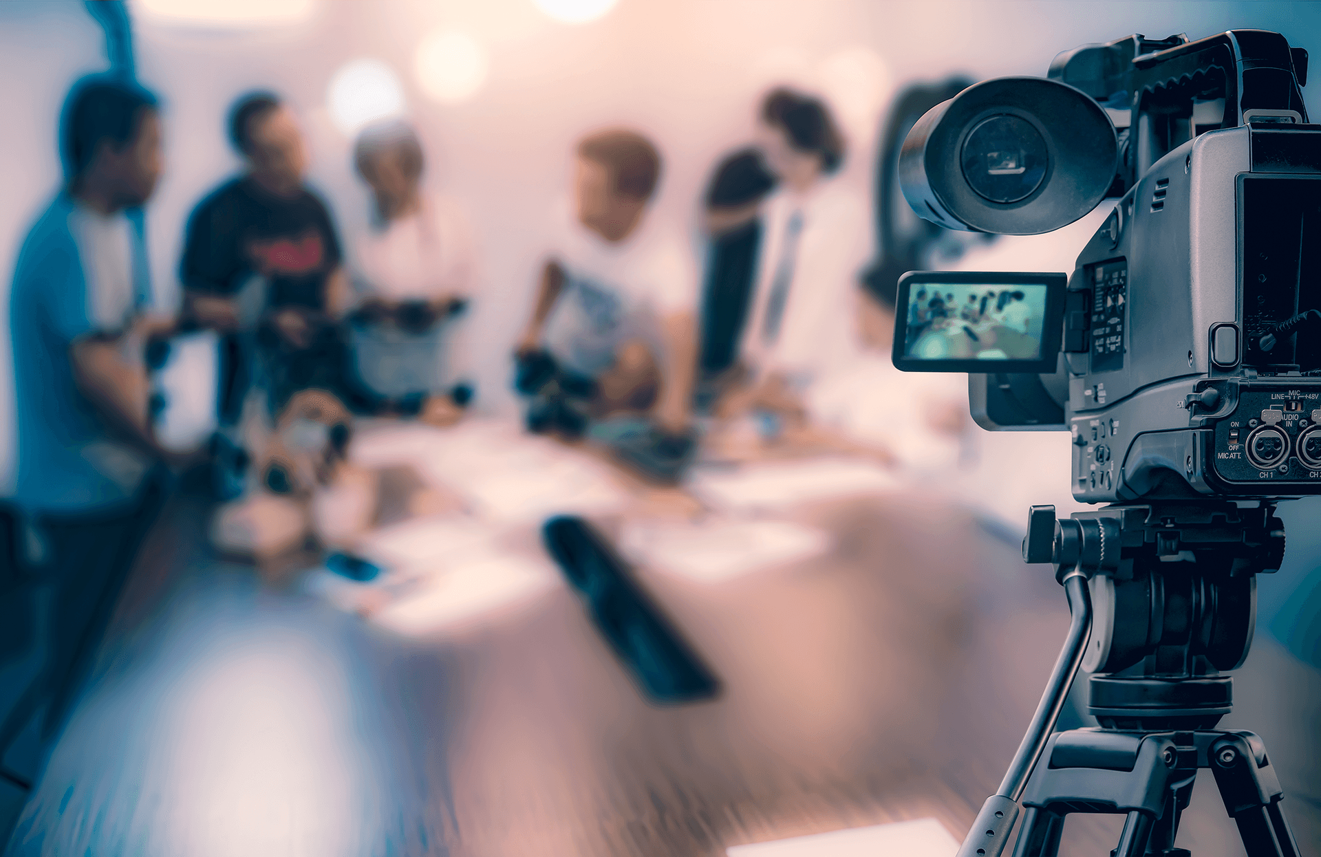 Video camera pointing at a group of people in a video shoot